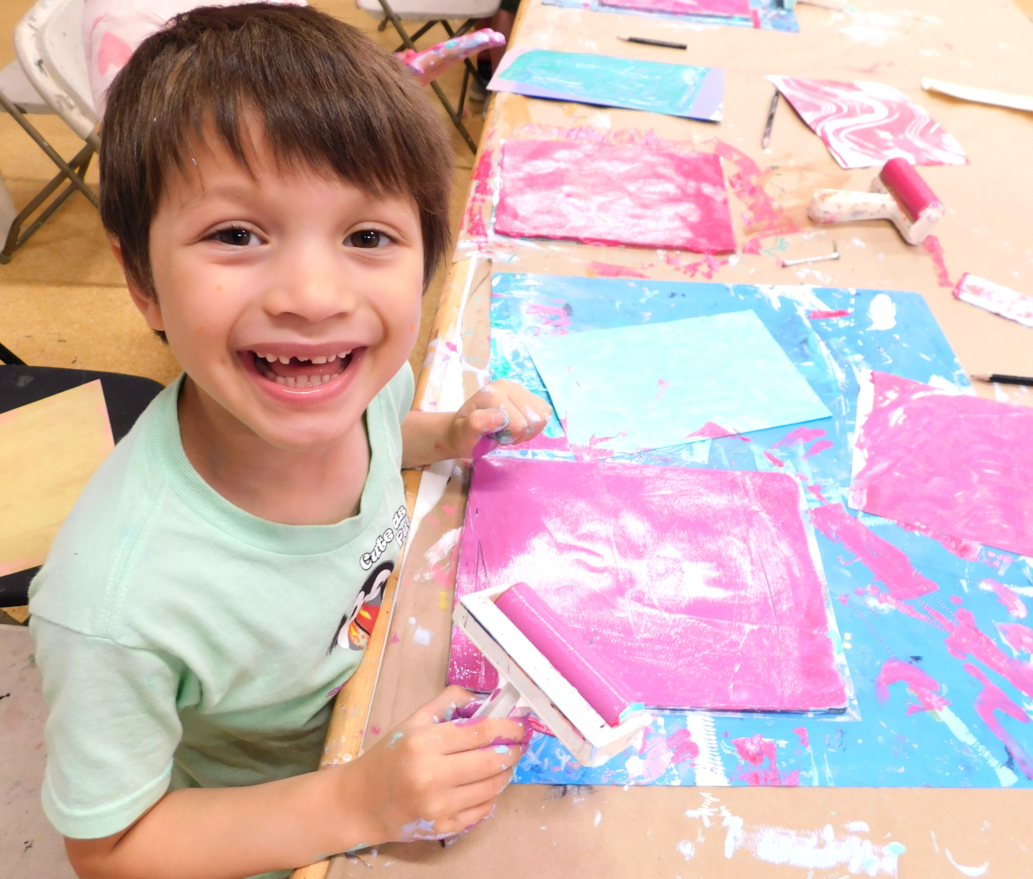 kid smiling at camera while painting
