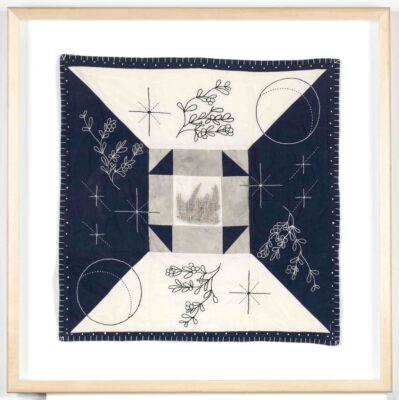 A blue and white quilted and embroidered fabric panel