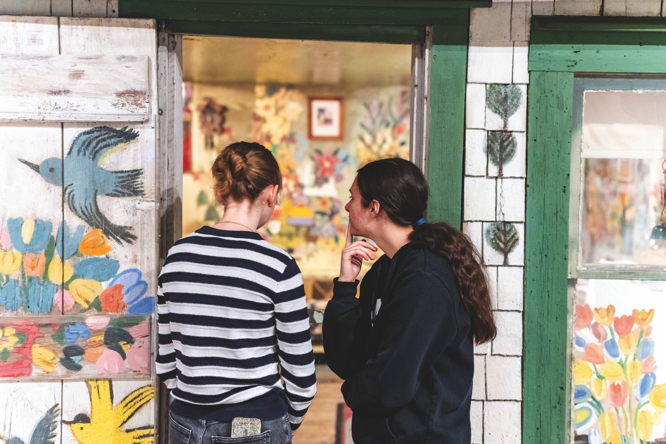 Two youth stand in front of the Maud Lewis House at the Art Gallery of Nova Scotia