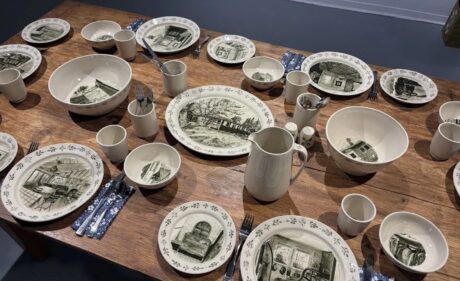 A wooden table set with illustrated ceramic dishes by artist Annika Sinclair