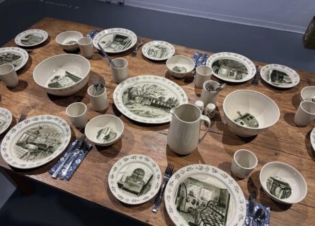 A wooden table set with illustrated ceramic dishes by artist Annika Sinclair