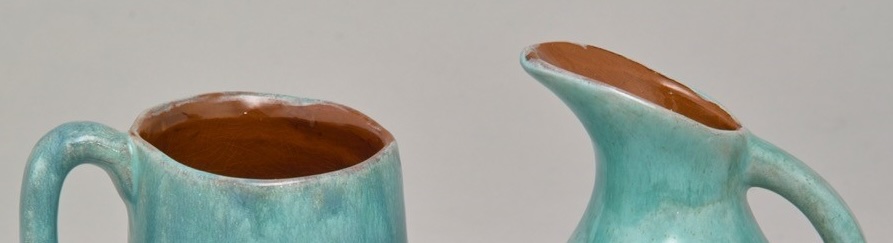 A light blue ceramic milk jug and creamer