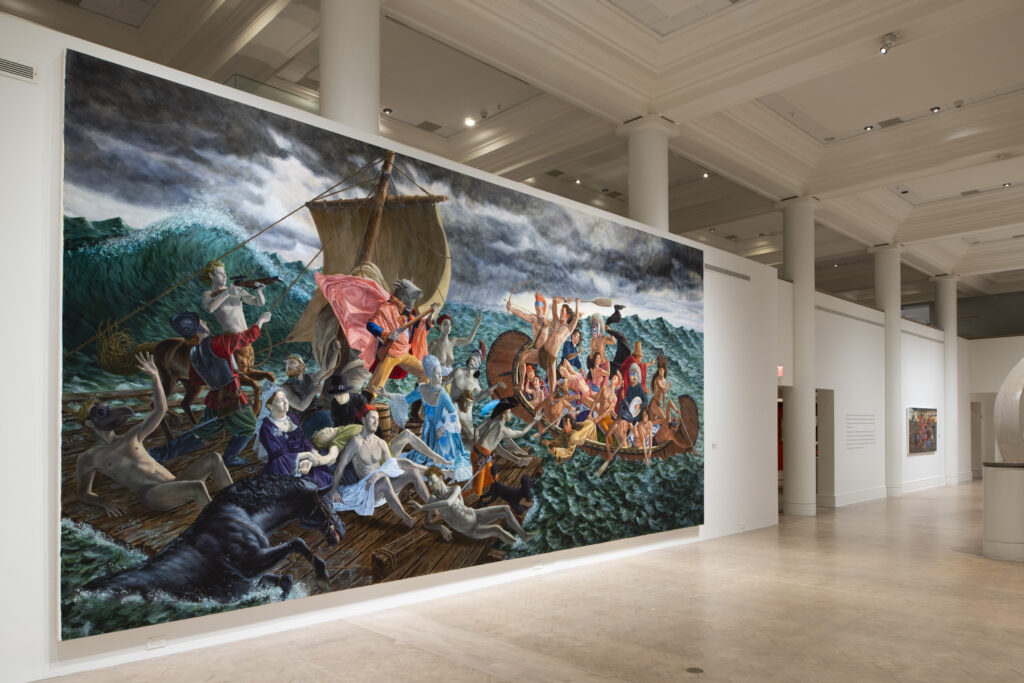 Angled installation view showing Kent Monkman's massive painting, Miss Chief's Wet Dream (2018), mounted on a white gallery wall.