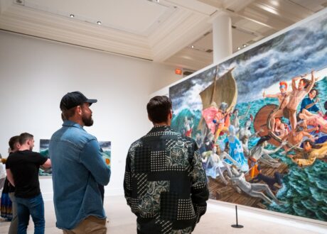 Four men look at a large painting in a Gallery