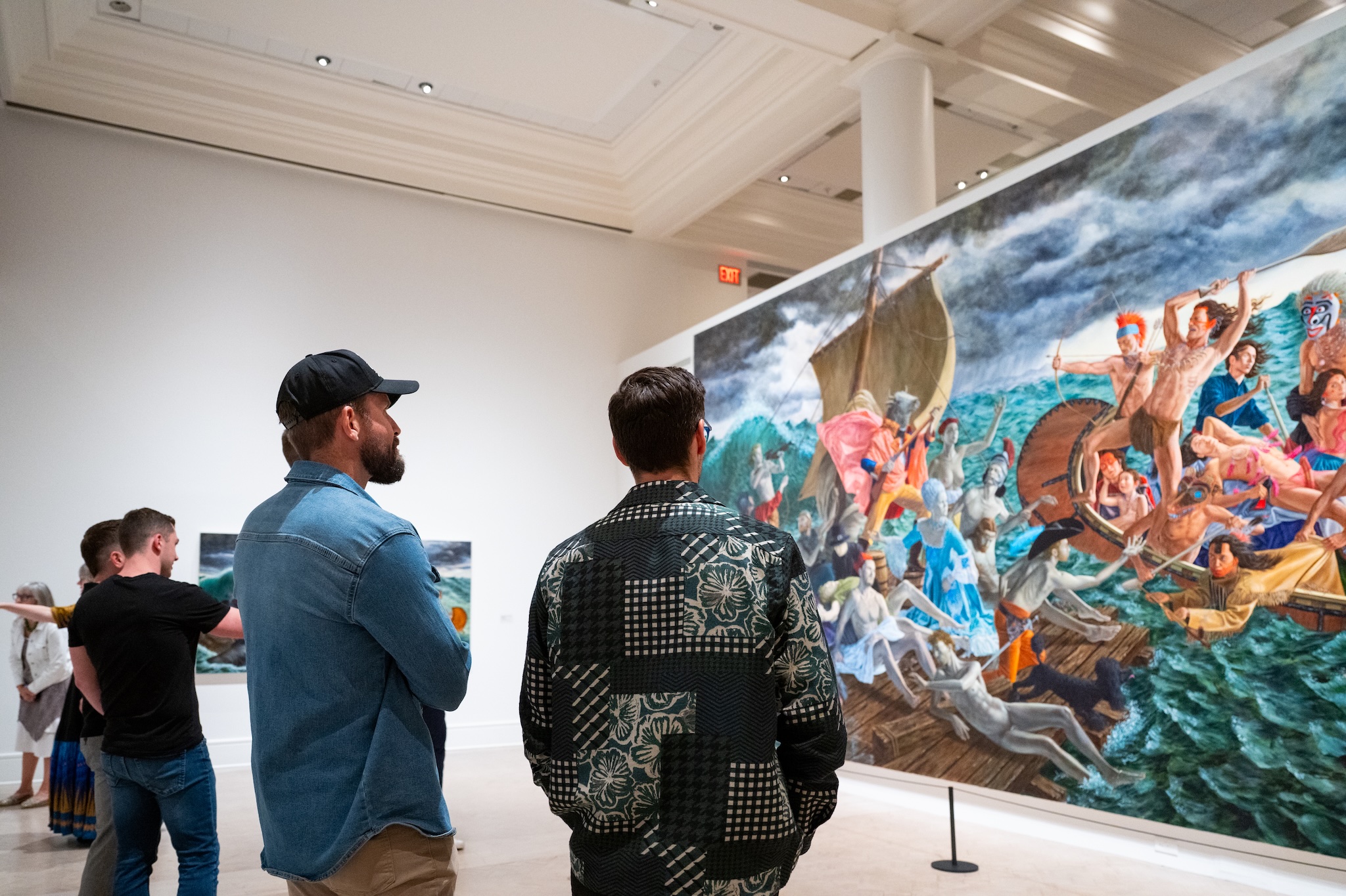 Four men look at a large painting in a Gallery