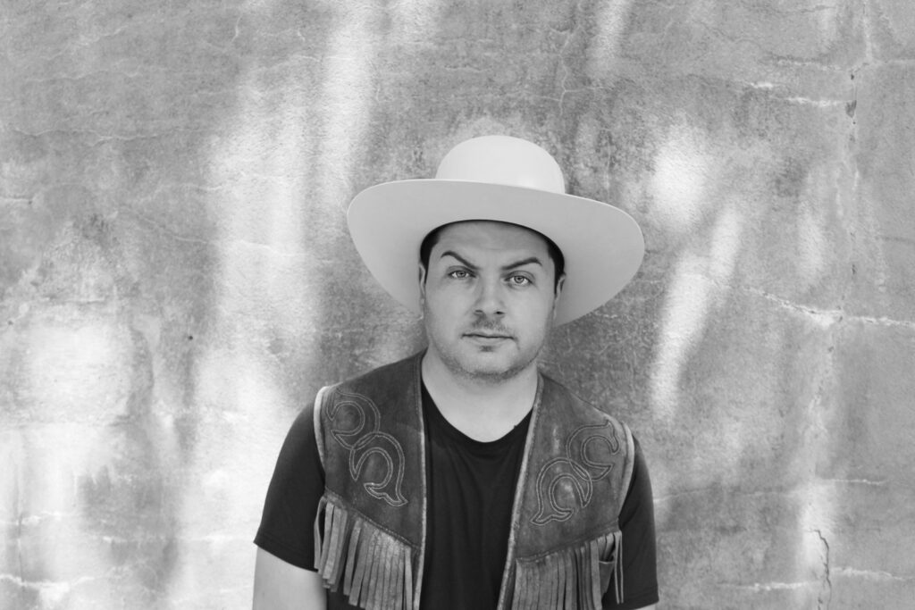 A black and white image of a man in a white hat